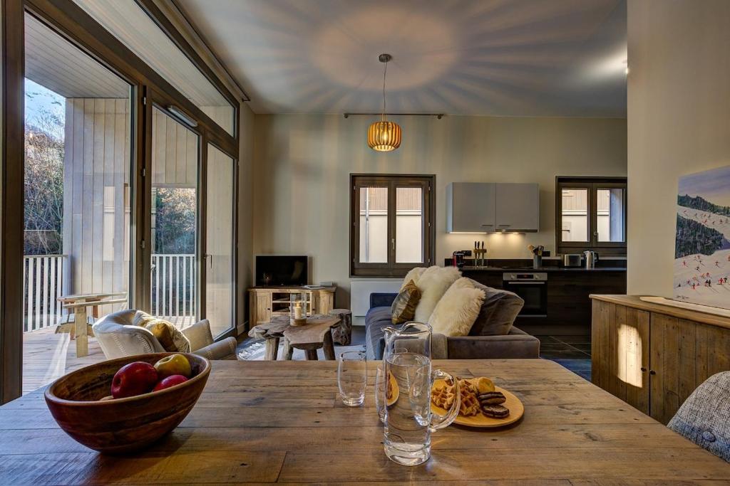 un salon avec une table avec un bol de fruits dessus dans l'établissement White Pearl Apartments, à Chamonix-Mont-Blanc