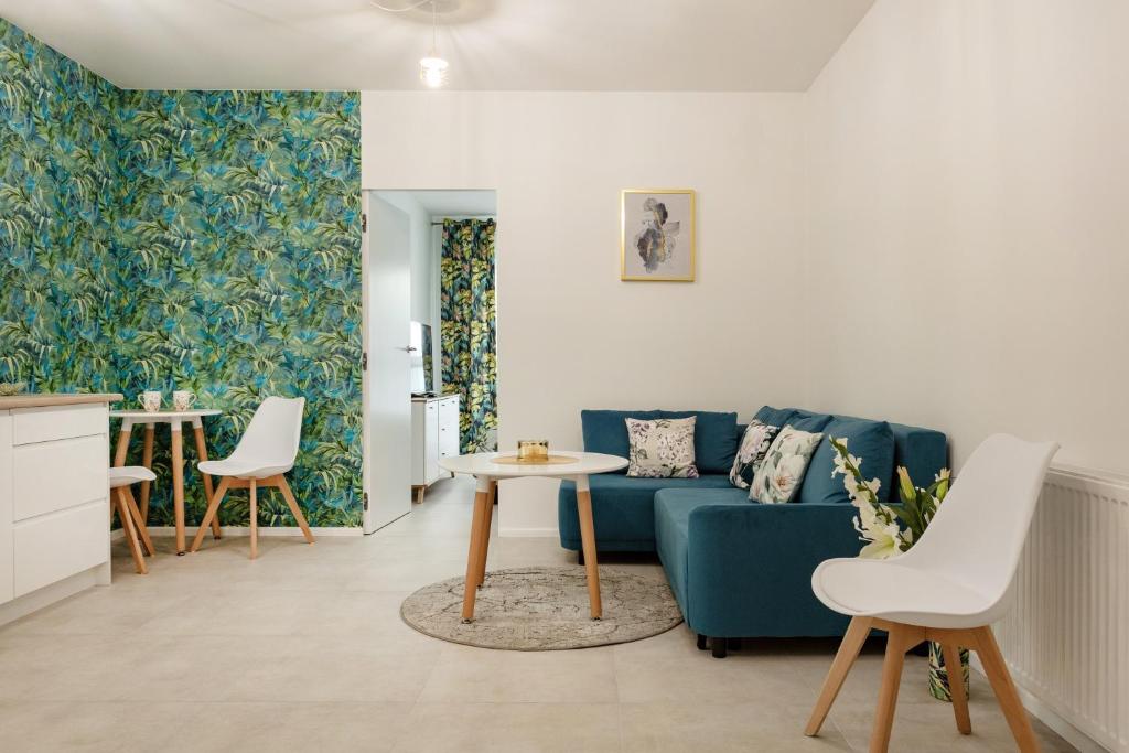 a living room with a blue couch and a table at Apartament Flora - apartament blisko morza in Gdańsk