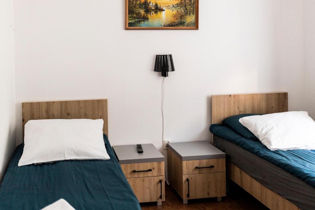 a room with two beds and a lamp and a table at Zajazd na Liwskich Mostach in Węgrów