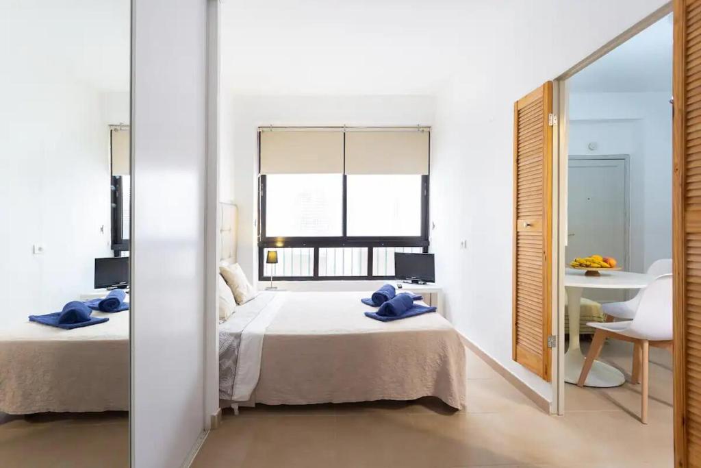 Habitación blanca con 2 camas y espejo. en Plaza del Príncipe, en Santa Cruz de Tenerife