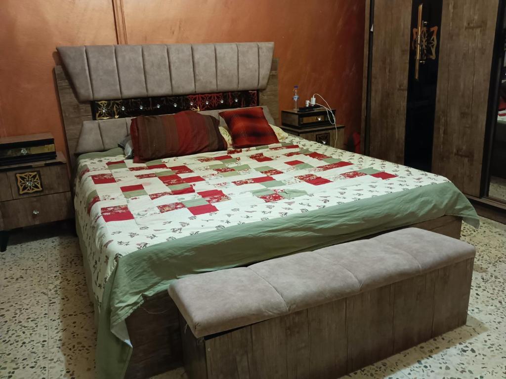 a bedroom with a large bed with a quilt on it at Flowers apartment in Amman