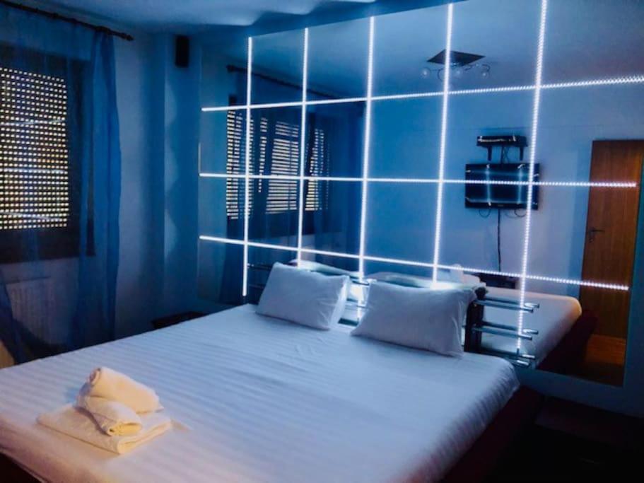 um quarto azul com uma cama grande e almofadas brancas em Joy City Stay Republicii 19 em Timişoara