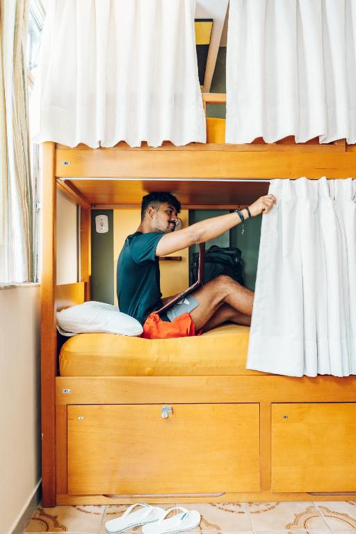 a man sitting on top of a bunk bed at Discovery Hostel in Rio de Janeiro