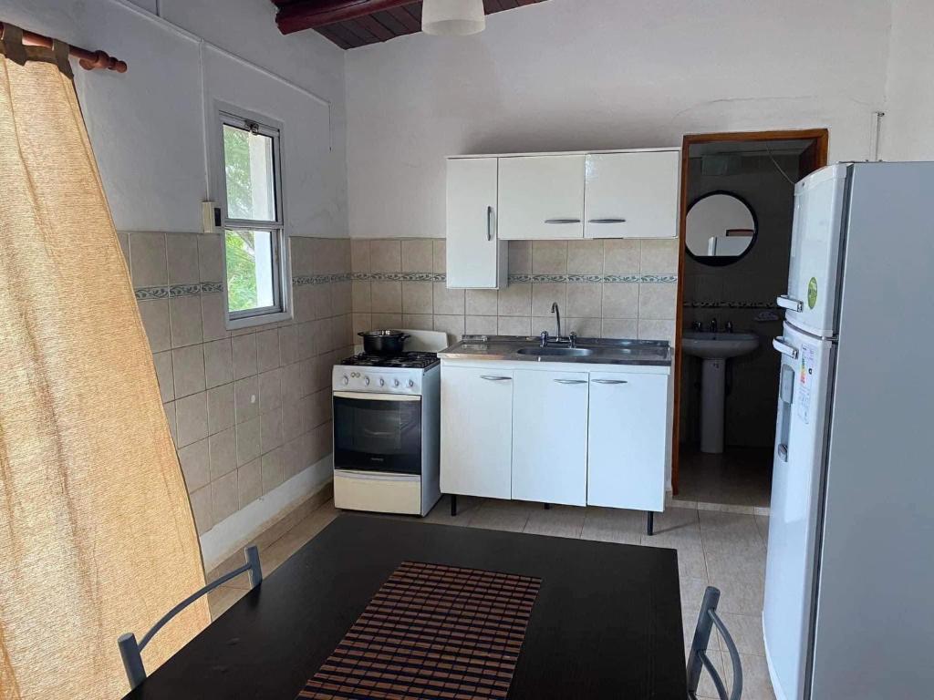 a kitchen with white cabinets and a sink and a refrigerator at Departamento termal in Federación