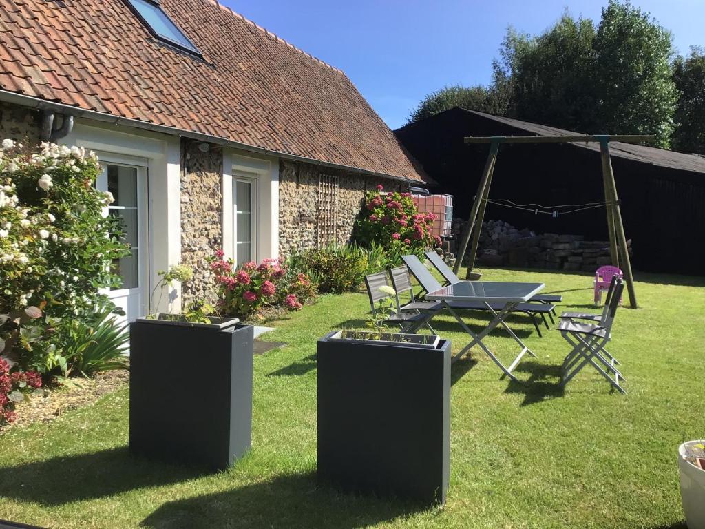 d'une terrasse avec une table et des chaises dans la cour. dans l'établissement GÎTE 2 Ferme de la Haute Escalles, à Escalles