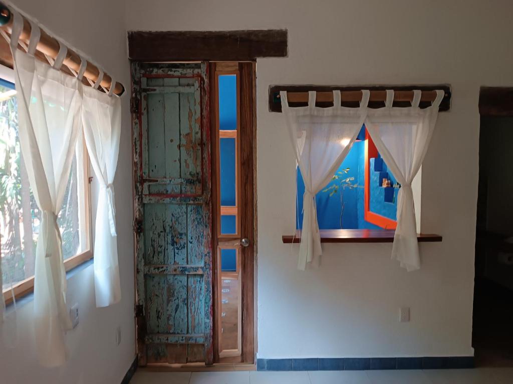 otwierane drzwi z zasłonami i oknem w obiekcie jungle lodge w mieście Cancún