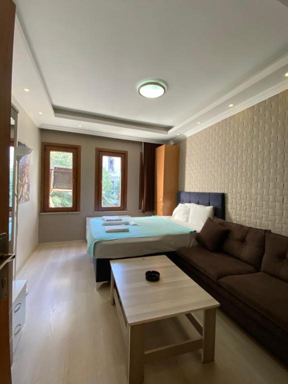 uma sala de estar com uma cama e um sofá em RİXOS PERA Apartment em Istambul