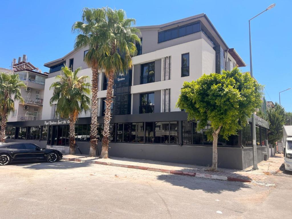 a white building with palm trees in front of it at Hayal Fener in Antalya