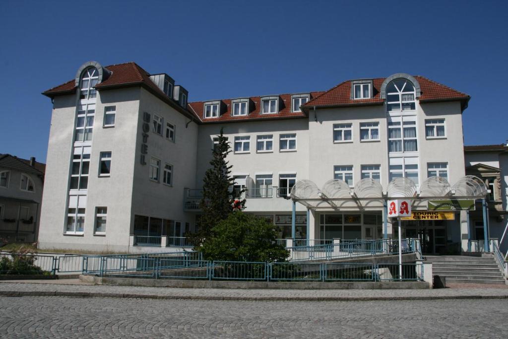 a large white building with a red roof at Atrium Hotel in Crimmitschau