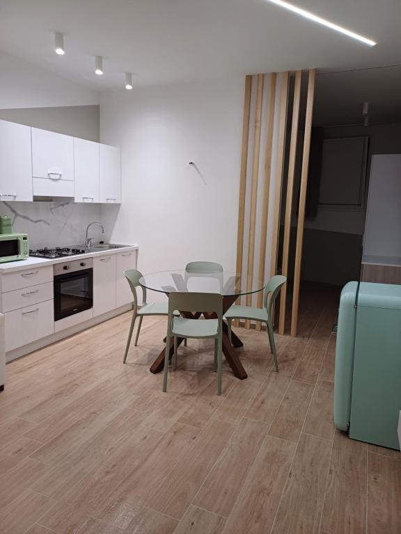 eine Küche und ein Esszimmer mit einem Tisch und Stühlen in der Unterkunft Appartamento Nonna Lina in Custonaci