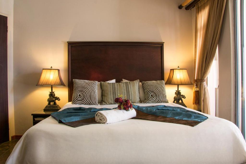 a bedroom with a large white bed with two lamps at Zoete Rust Guesthouses in Lephalale