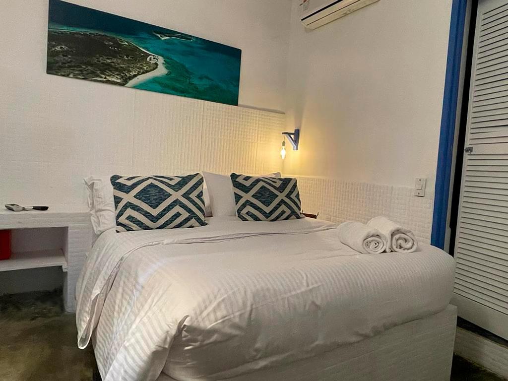 Un dormitorio con una cama blanca con toallas. en Posada Lagunita en Los Roques