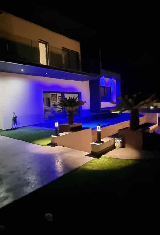 une personne marchant devant une maison la nuit dans l'établissement Chambre de luxe, spa, piscine, entre mer et montagne, à Villelongue-dels-Monts