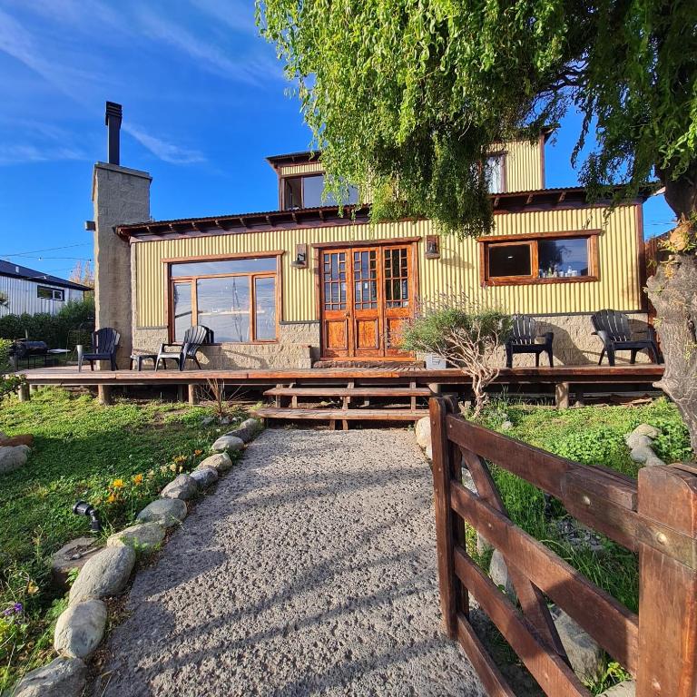 a house with a fence in front of it at Cabañas y Hostel I Keu Ken in El Calafate
