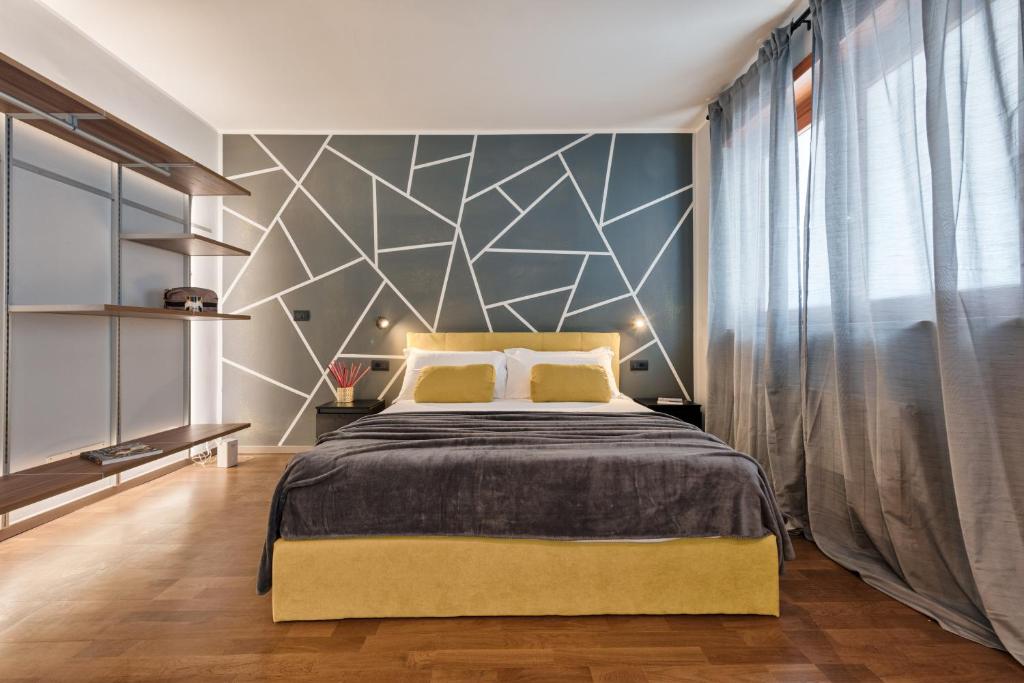 a bedroom with a large bed with a geometric wall at Casa RIGOLA by Apartments To Art in Venaria Reale