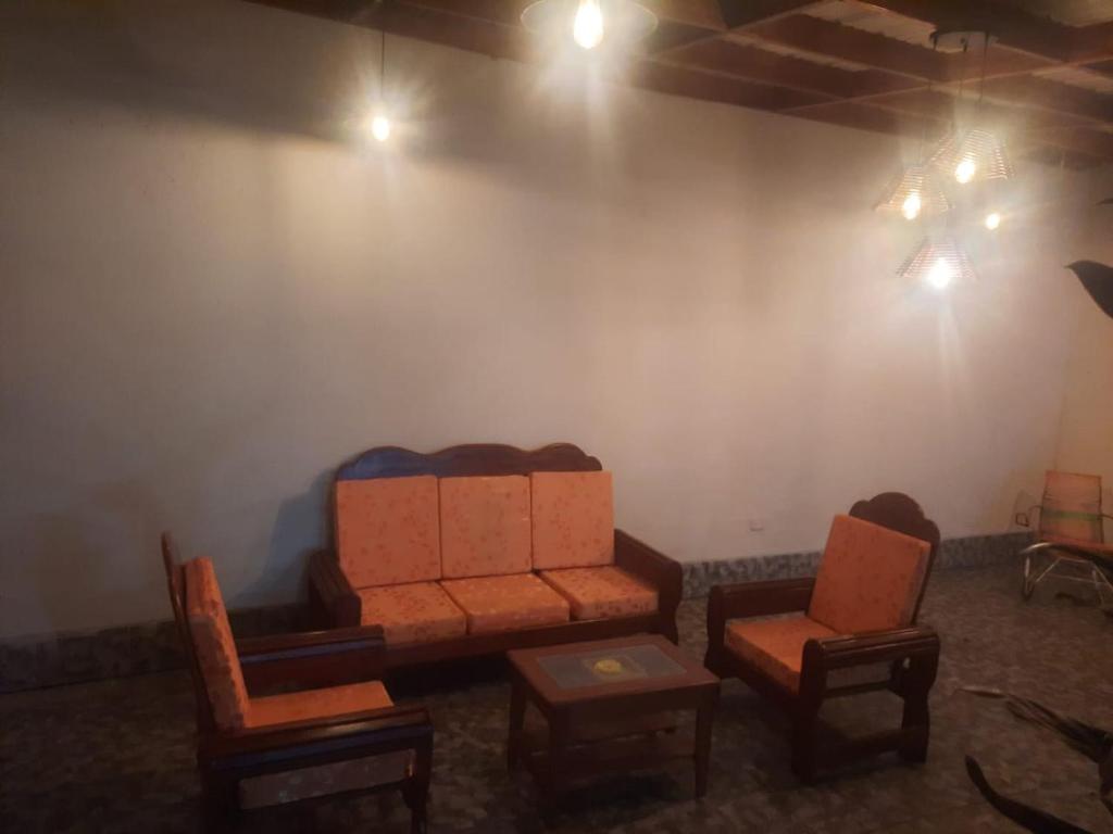 sala de estar con 2 sillas y sofá en Alojamiento Casa Grande en Iquitos