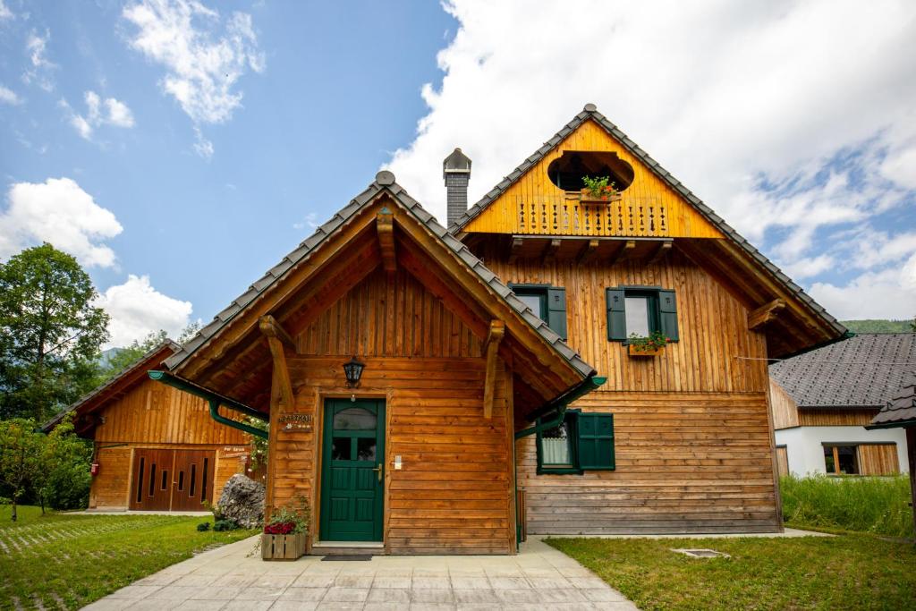 Casa de madera grande con puerta verde en Apartments Omahen, en Bohinj