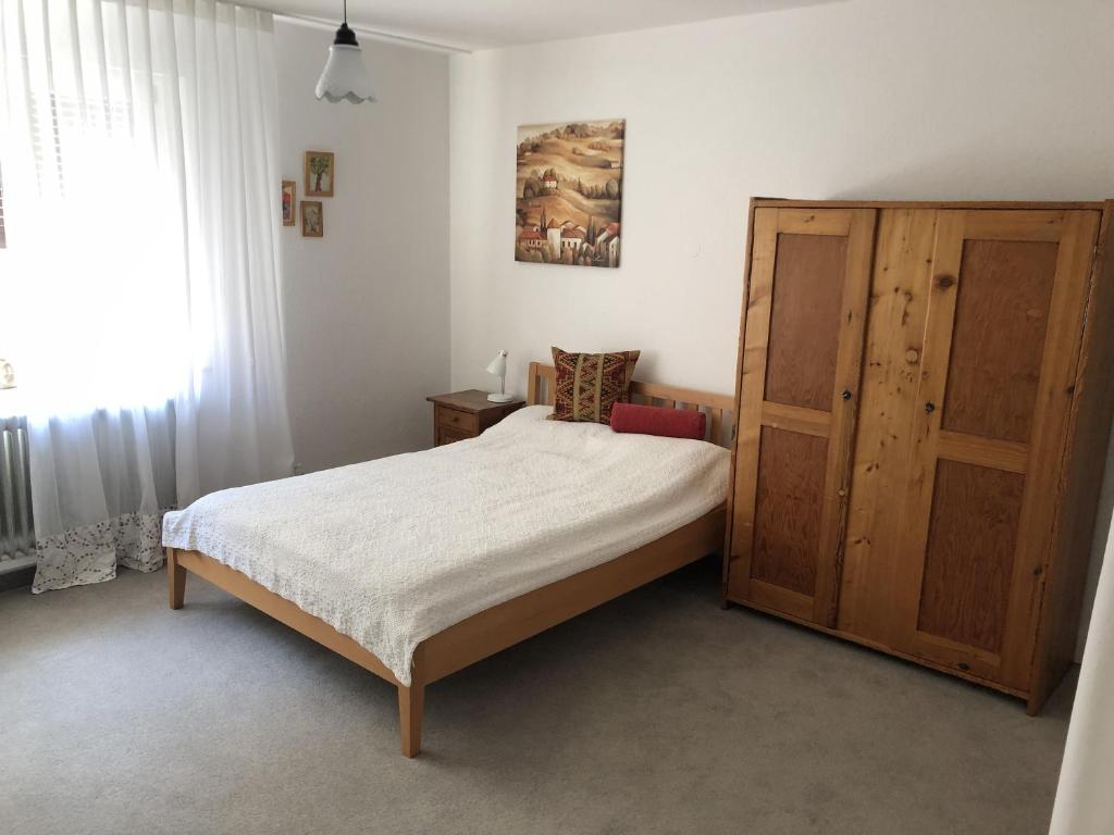 a bedroom with a bed and a wooden cabinet at Ferienwohnung Innenstadt in Marktbreit