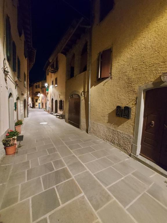 an empty street in an alley at night at Casa Lorenzo - nel centro storico di Fiumalbo in Fiumalbo