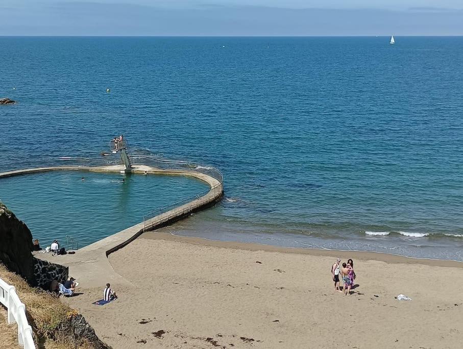 un grupo de personas en una playa cerca del océano en les pieds dans l'eau à 50 mètres de la mer, en Saint-Quay-Portrieux