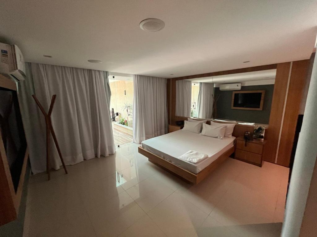 HOTEL PORTELÃO في ريو دي جانيرو: غرفة نوم بسرير ومرآة كبيرة