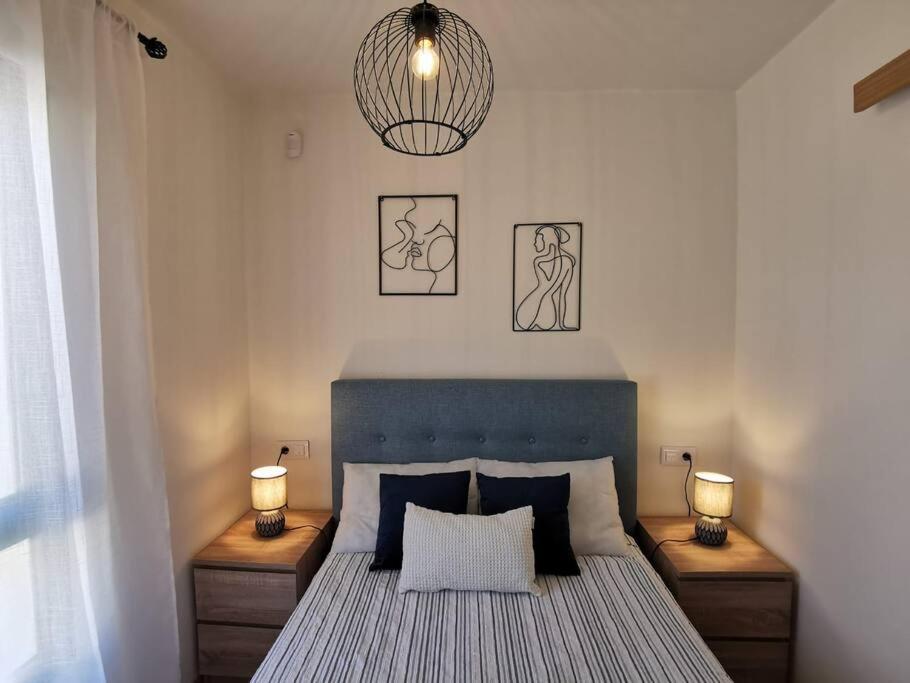 una camera da letto con un letto con due luci sul muro di Montes Blancos a Costa Calma