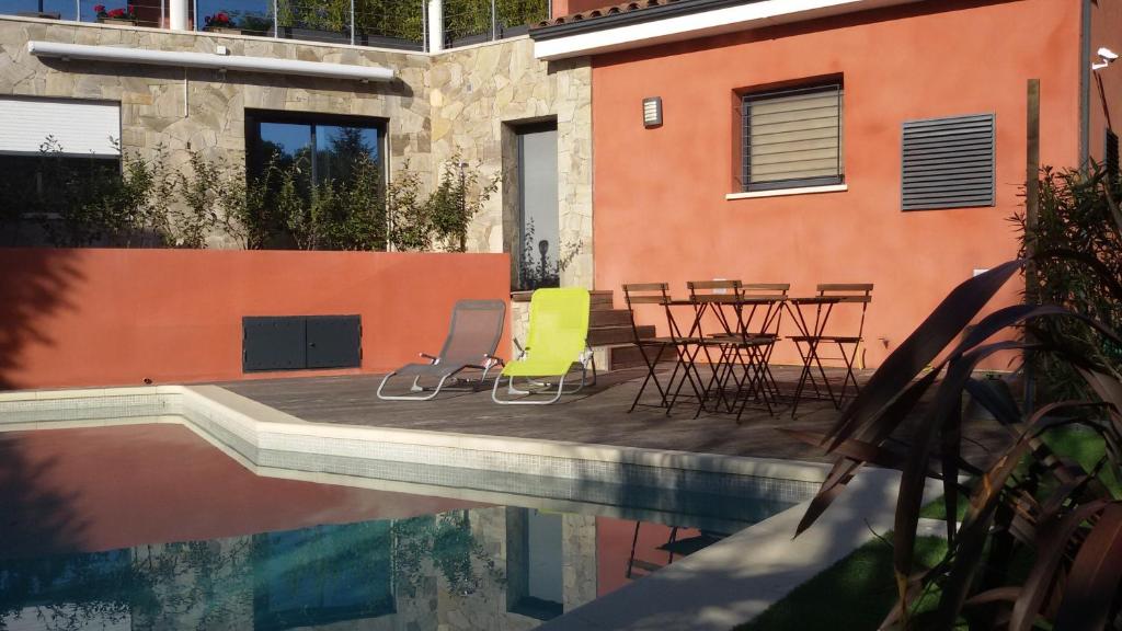 un patio con sillas y una mesa junto a la piscina en Villa Esterel Plage, en Saint-Raphaël
