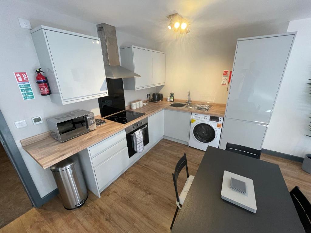 een keuken met witte kasten en een fornuis met oven bij Ideal family apartment in Bolsover sleeps 4 in Chesterfield