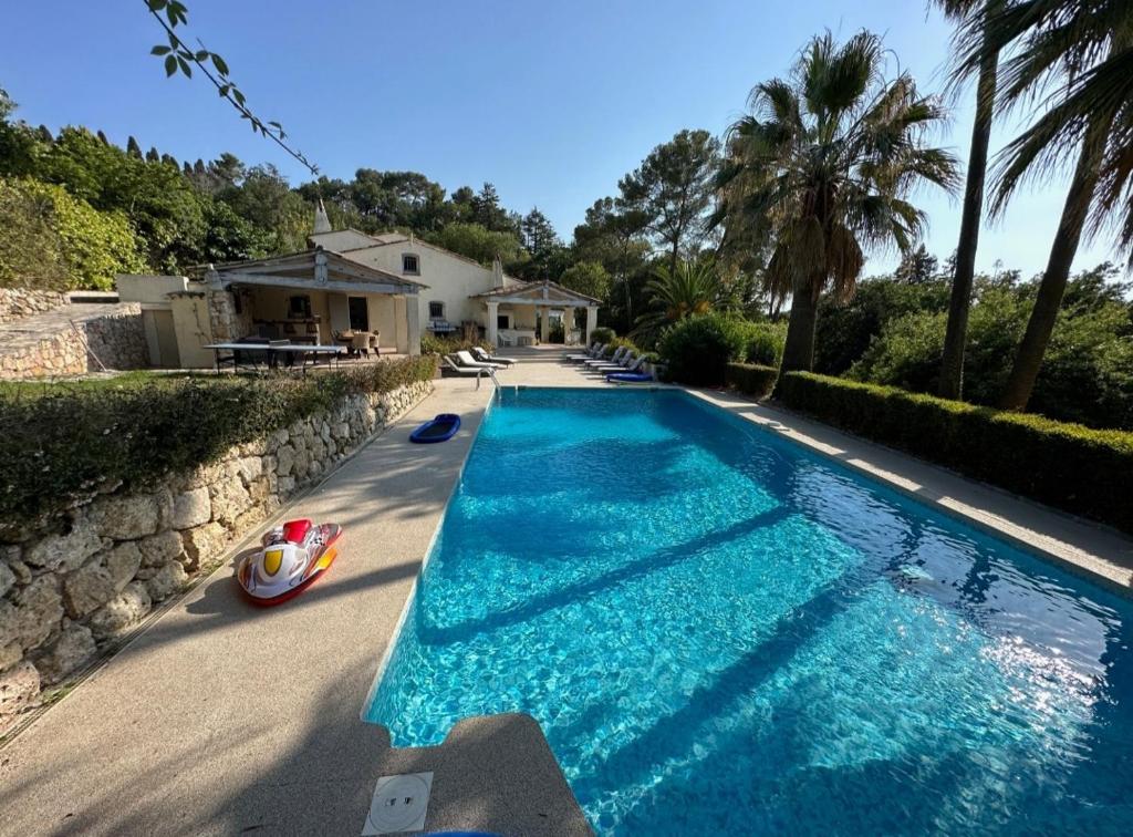 une piscine avec de l'eau bleue devant une maison dans l'établissement Villa paradisiaque 10 couchages, à Mougins
