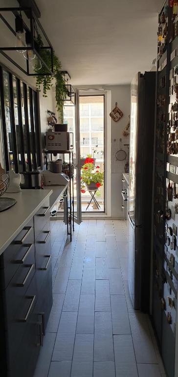 cocina con suelo de baldosa blanca y ventana grande en RESIDENCE AURORE, en Ermont
