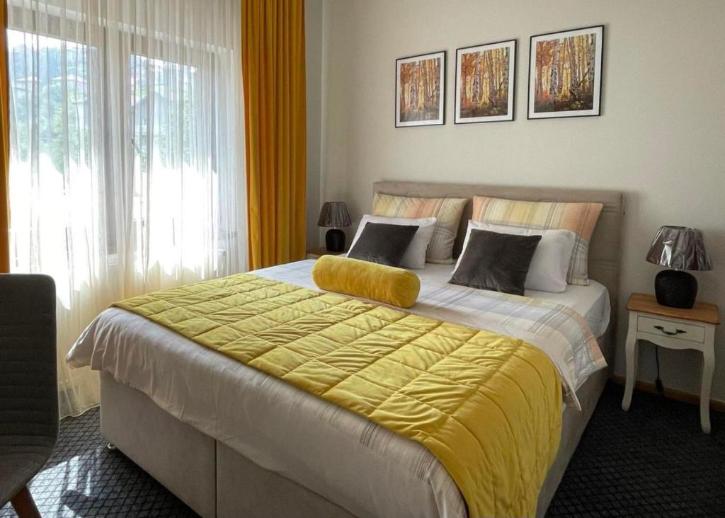 een slaapkamer met een bed met een gele deken erop bij Bed & Breakfast Sjaj in Sarajevo