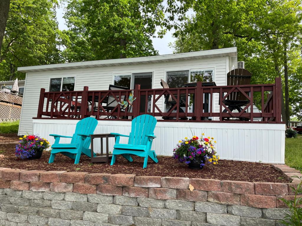 dos sillas azules y una mesa frente a una casa en Knotty Pine Haven C1, en Greenville