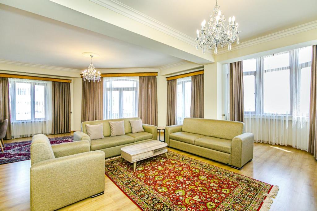 a living room with two couches and a chandelier at Luxary Home Millennium in Baku