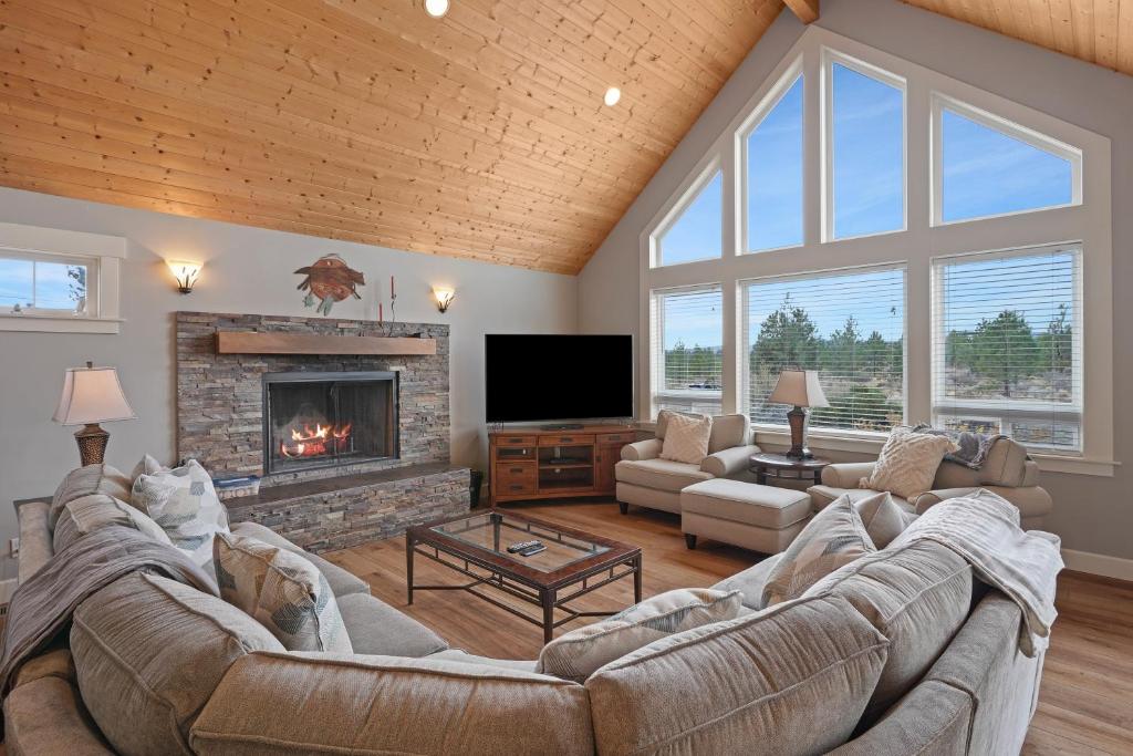 a living room with a large couch and a fireplace at Five Peaks Home with Soaking Tub in Bend