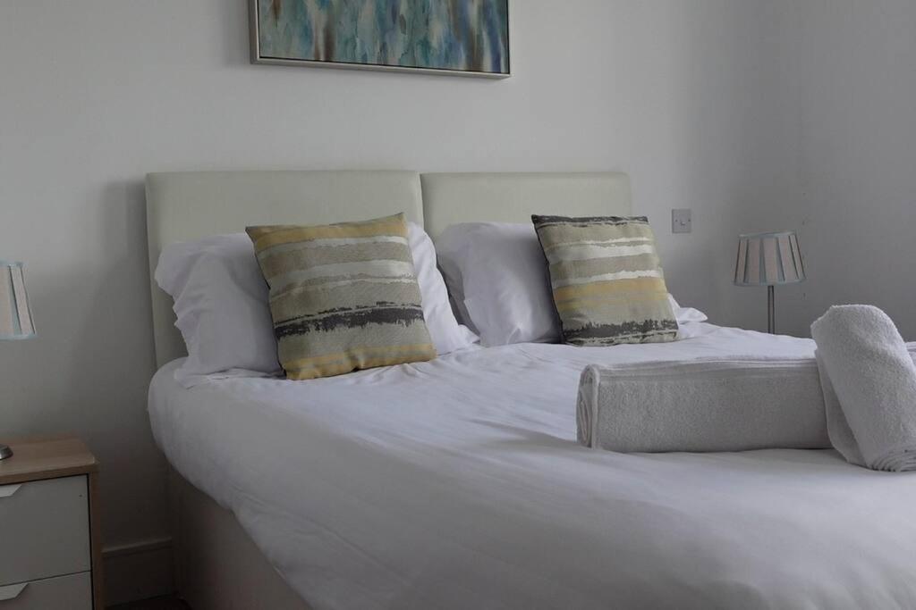a white bed with two pillows on top of it at Guest Homes - Axial Apartment in Colchester