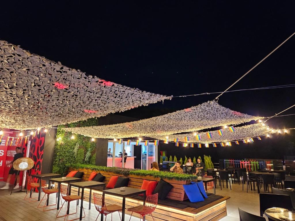 a restaurant with tables and chairs and lights at night at Lloret Vibe Affiliated by FERGUS in Lloret de Mar
