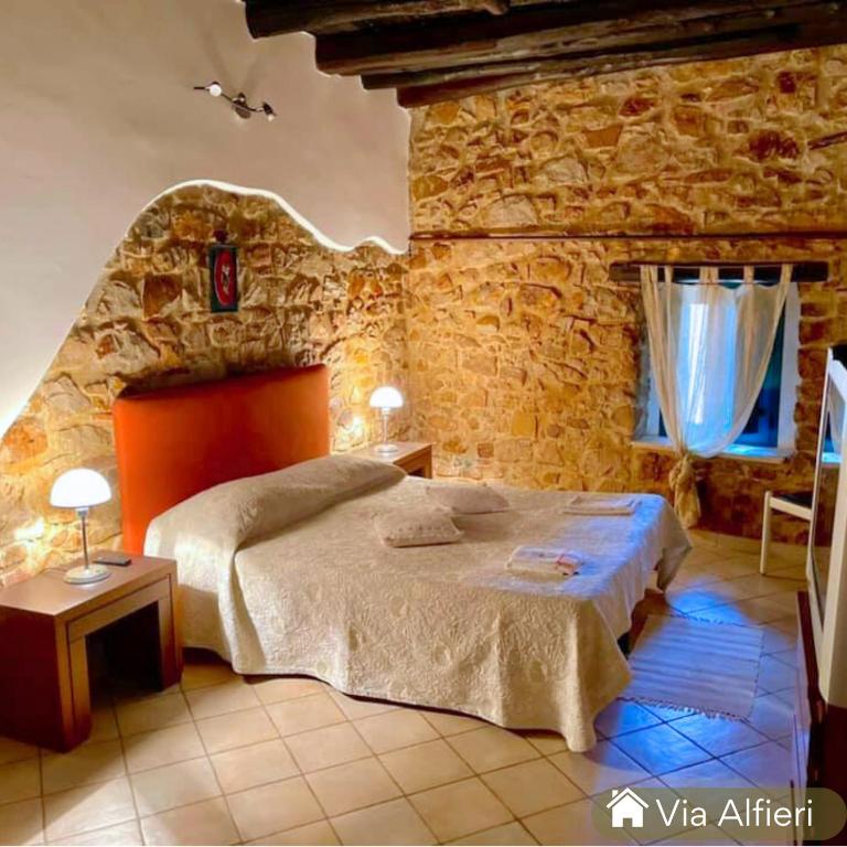 a bedroom with a bed and a stone wall at Casa centro storico borgo medievale in San Mauro Castelverde