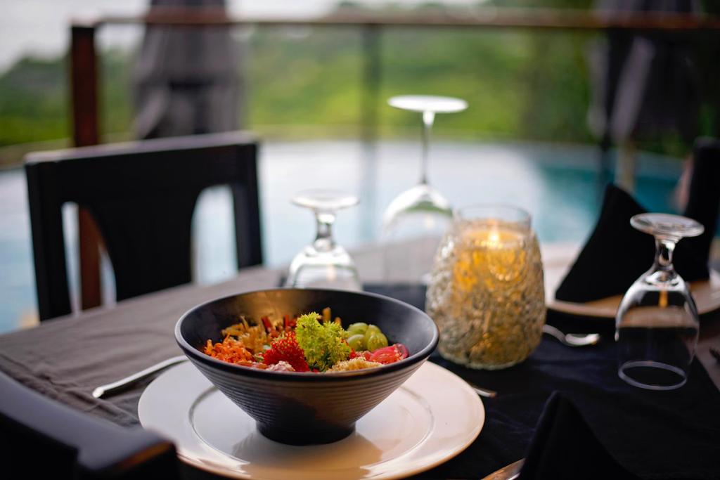 a bowl of food sitting on a table with a plate at Villa Roca Boutique Resort & Suites - ADULT ONLY in Manuel Antonio