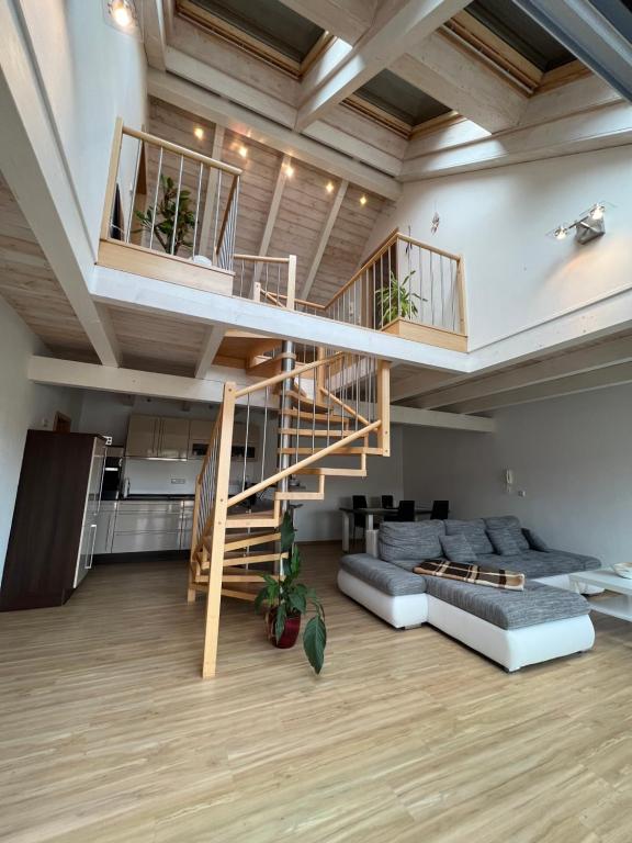 a living room with a staircase and a couch at Ferienwohnung mit Balkon in Oberelsbach