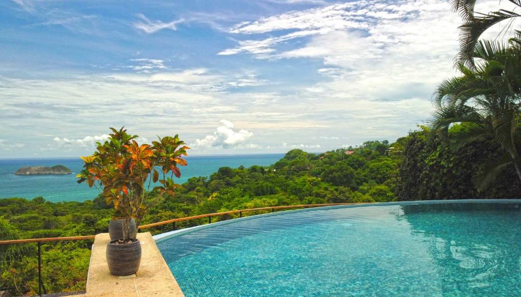 a swimming pool with a view of the ocean at Villa Roca Boutique Resort & Suites - ADULT ONLY in Manuel Antonio