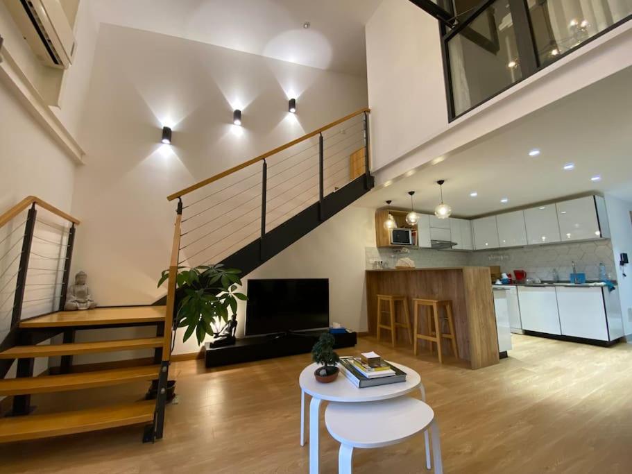 a living room with a staircase and a table and a kitchen at Pépite au centre ville avec vue sur la Cathédrale in Saint-Denis