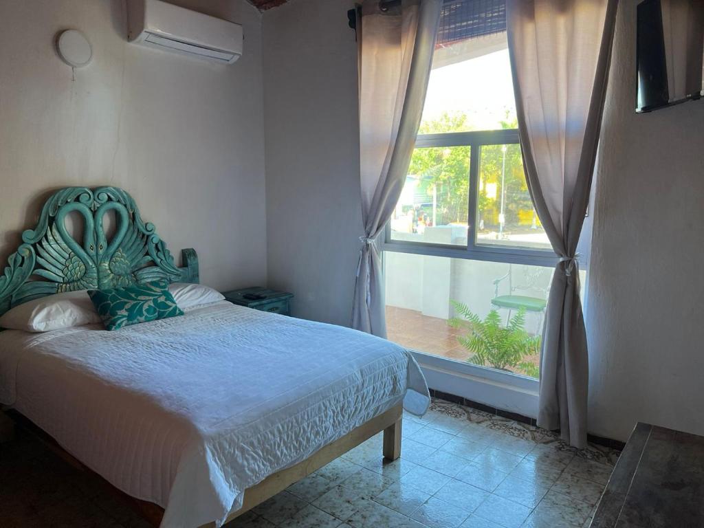 a bedroom with a bed and a large window at HOTEL VILLAS EL DORADO in Rincon de Guayabitos