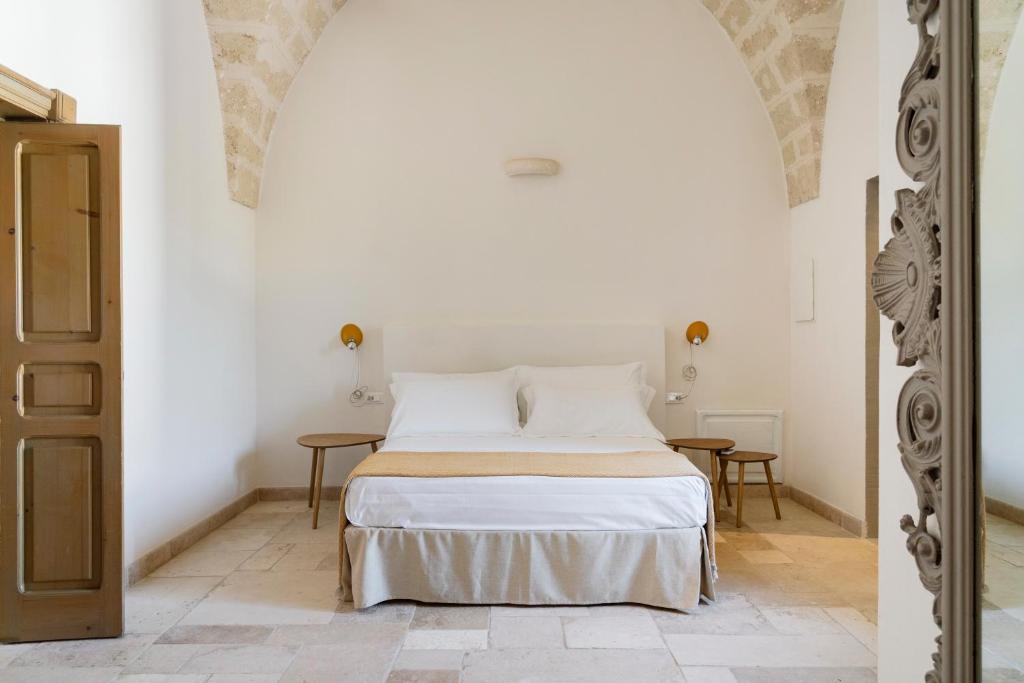 a bedroom with a bed in a white room at Masseria Gorgognolo in Ostuni