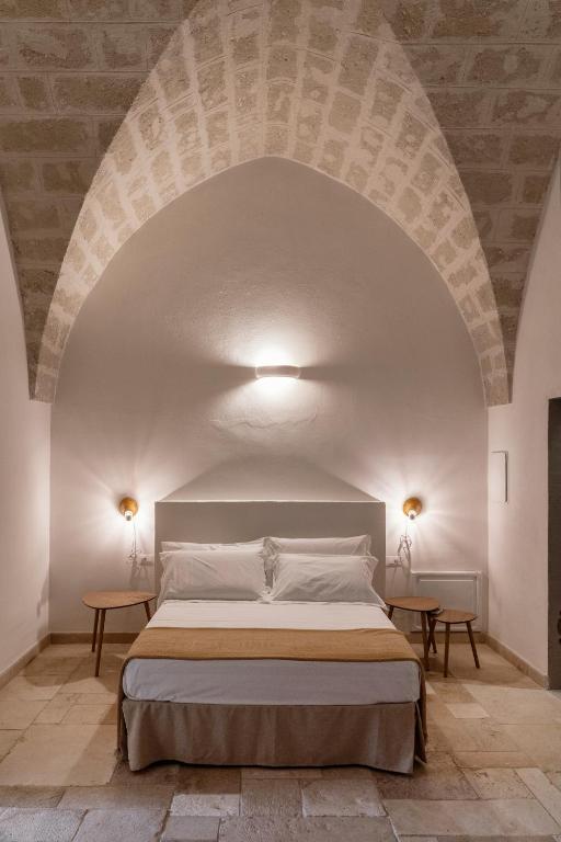 a bedroom with a large bed in an archway at Masseria Gorgognolo in Ostuni