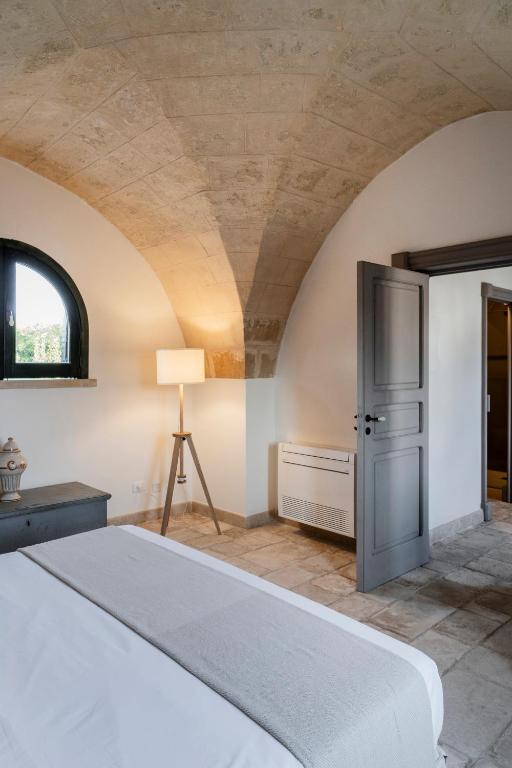 a bedroom with a bed and a vaulted ceiling at Masseria Gorgognolo in Ostuni