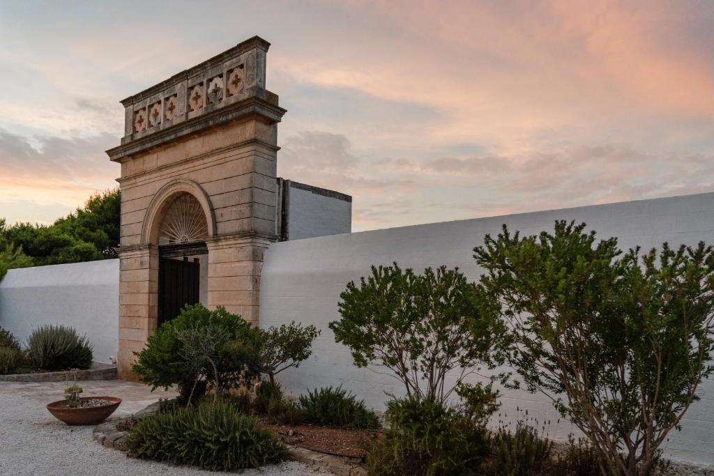 a building with a clock tower on the side of it at Masseria Gorgognolo in Ostuni