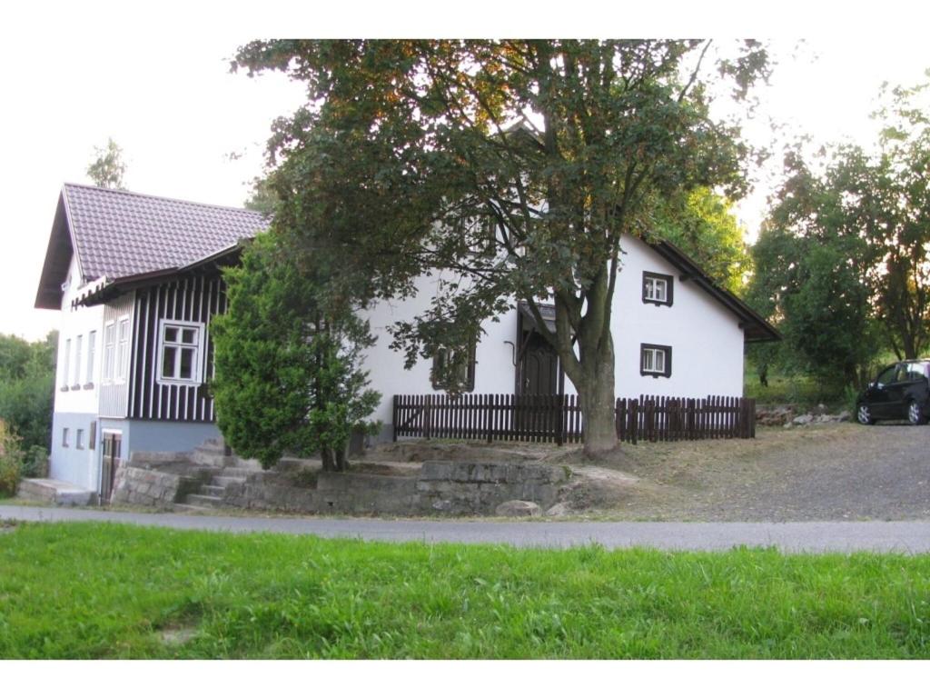 ein weißes Haus mit einem Baum davor in der Unterkunft Holiday home in a quiet authentic mountain village with a view of the surrounding hills in Zlatá Olešnice
