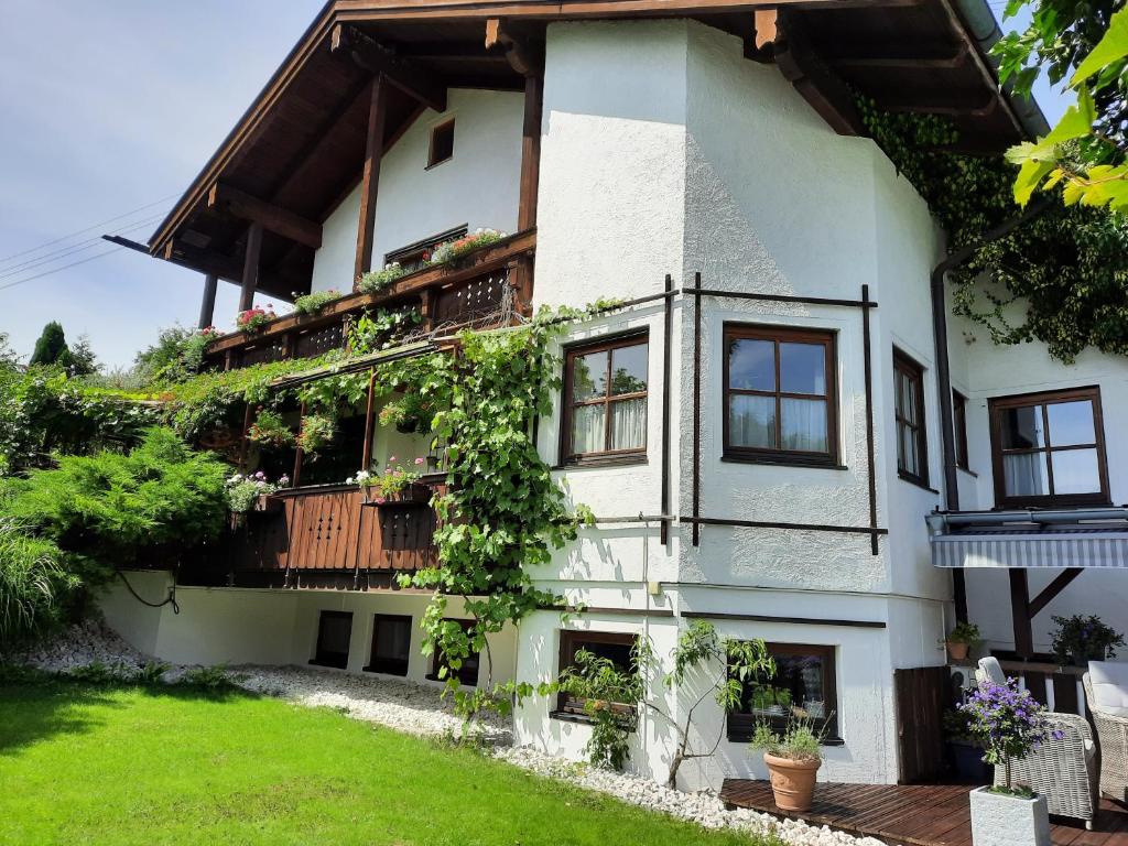 una casa blanca con plantas en los balcones en FeWo Auer, en Bischofswiesen