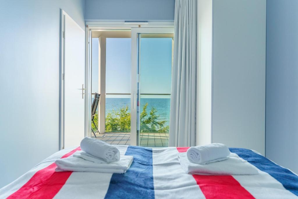 a bedroom with a bed with a view of the ocean at Apartament Kapitański z widokiem na morze 4 Piętro - by Perłowa Przystań Rent in Sianozety