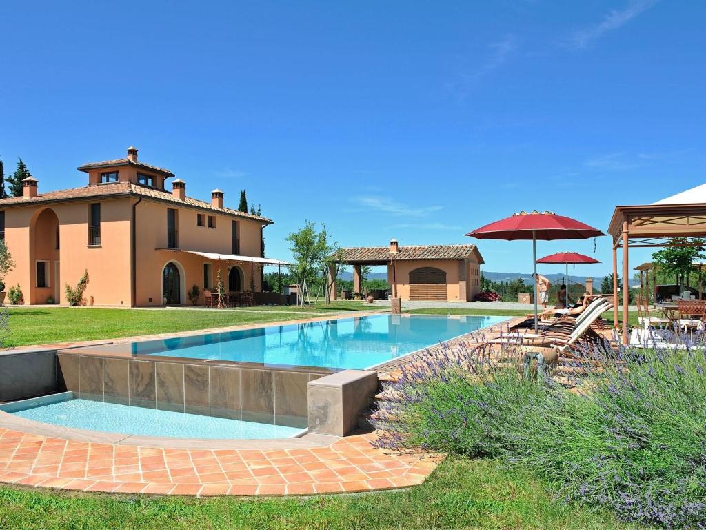 a swimming pool in front of a house at Pleasant villa in Peccioli with private swimming pool in Montelopio